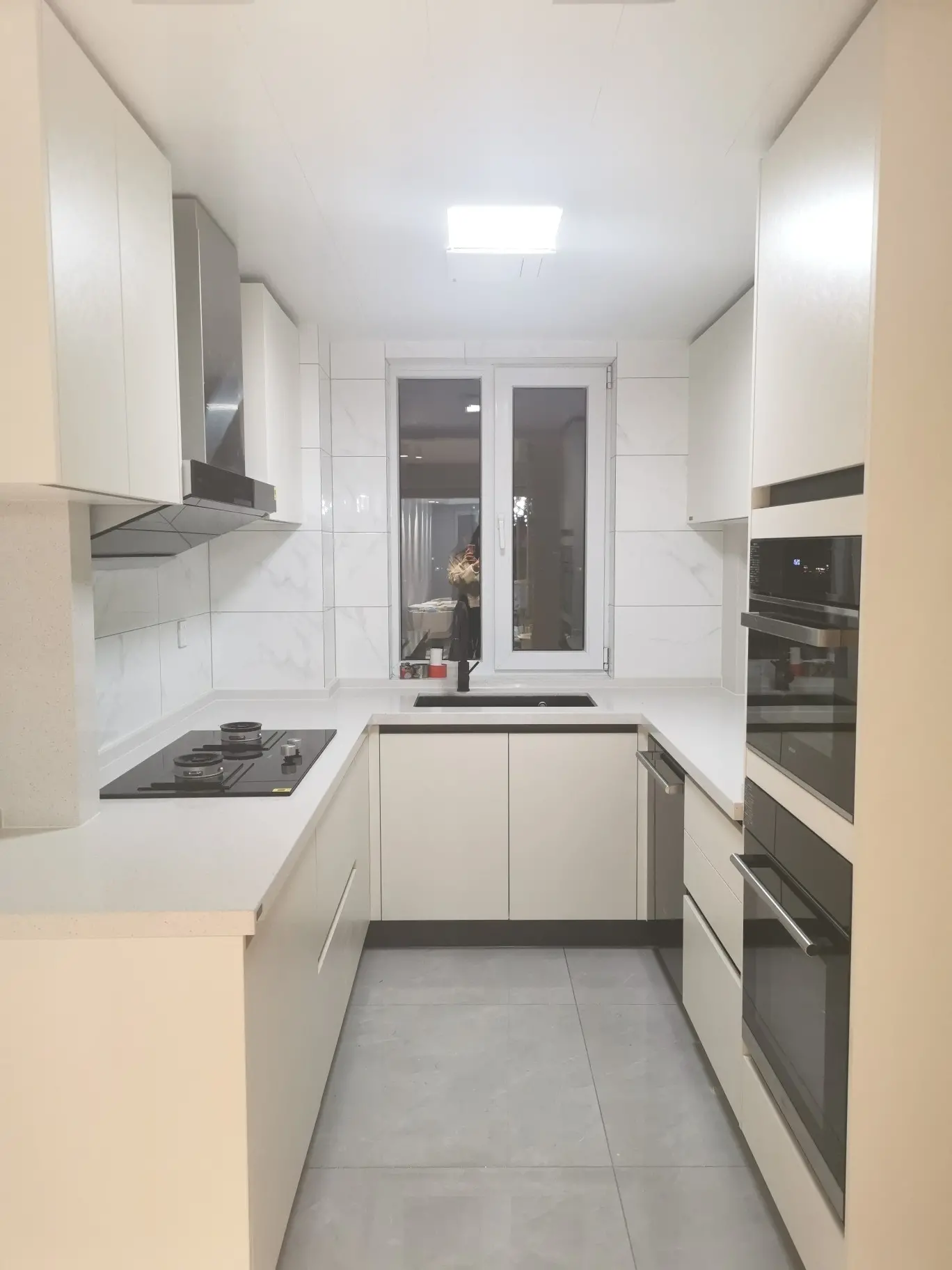 U-Shaped White Kitchen with Marble Backsplash